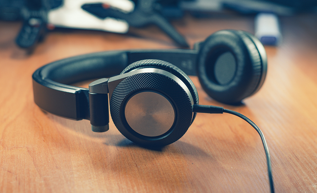 A pair of over-the-ear headphones sits on a table.