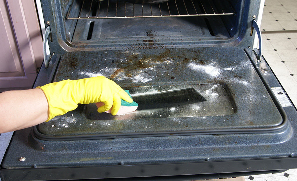 A person cleans an oven.