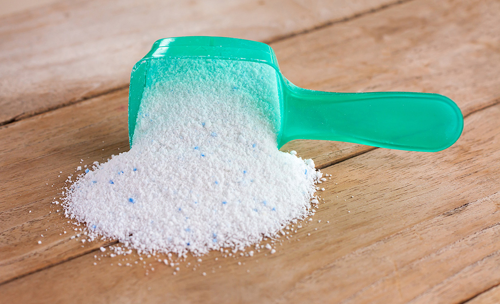 A scoop full of laundry detergent on a table.