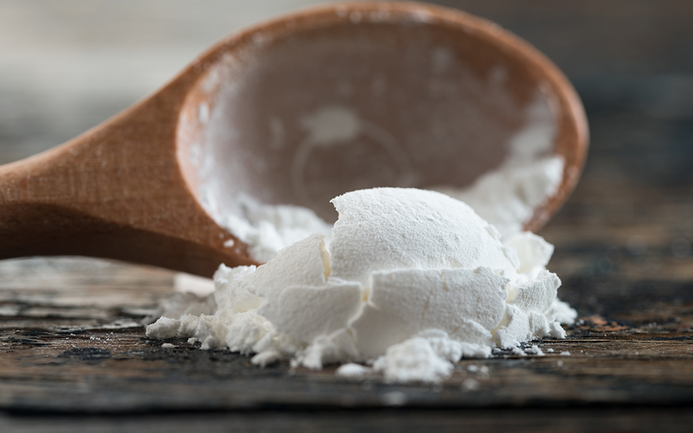 A wooden spoon with powdered corn starch.