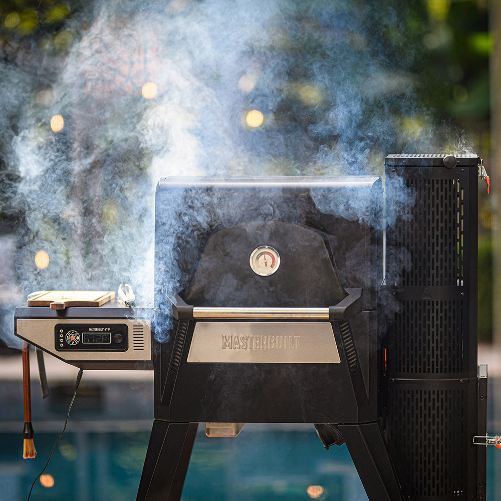 A Masterbuilt smoker with smoke coming out of it.