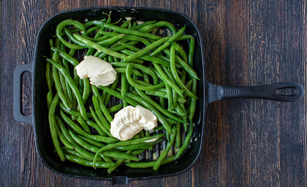 Buttery, smoked green beans in a skillet.