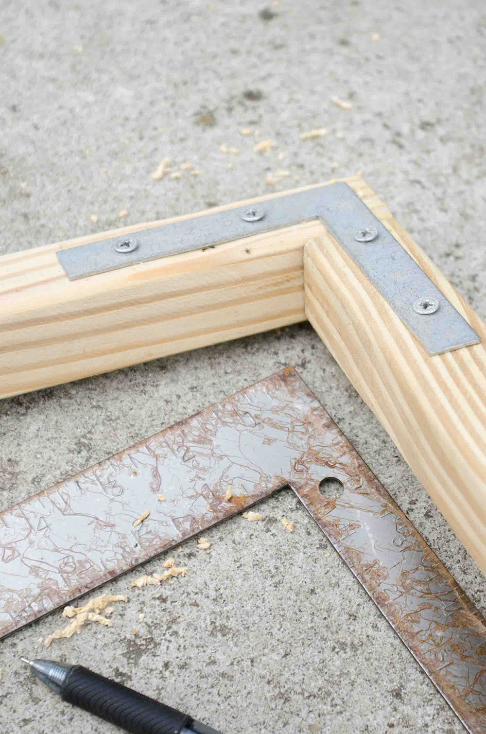A corner brace connects two pieces of wood.