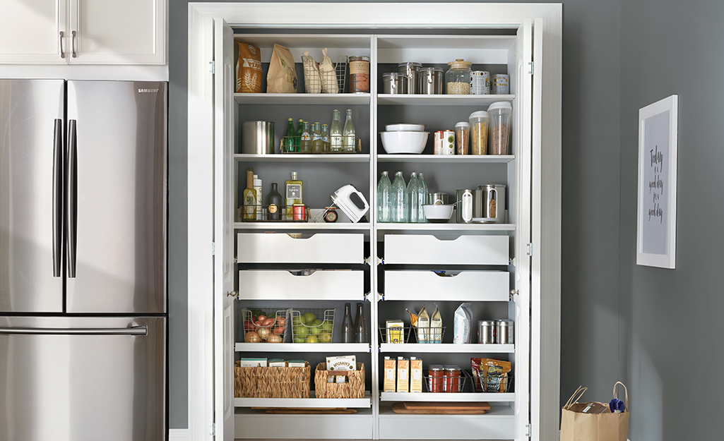 A well organized pantry featuring shelves and drawers.