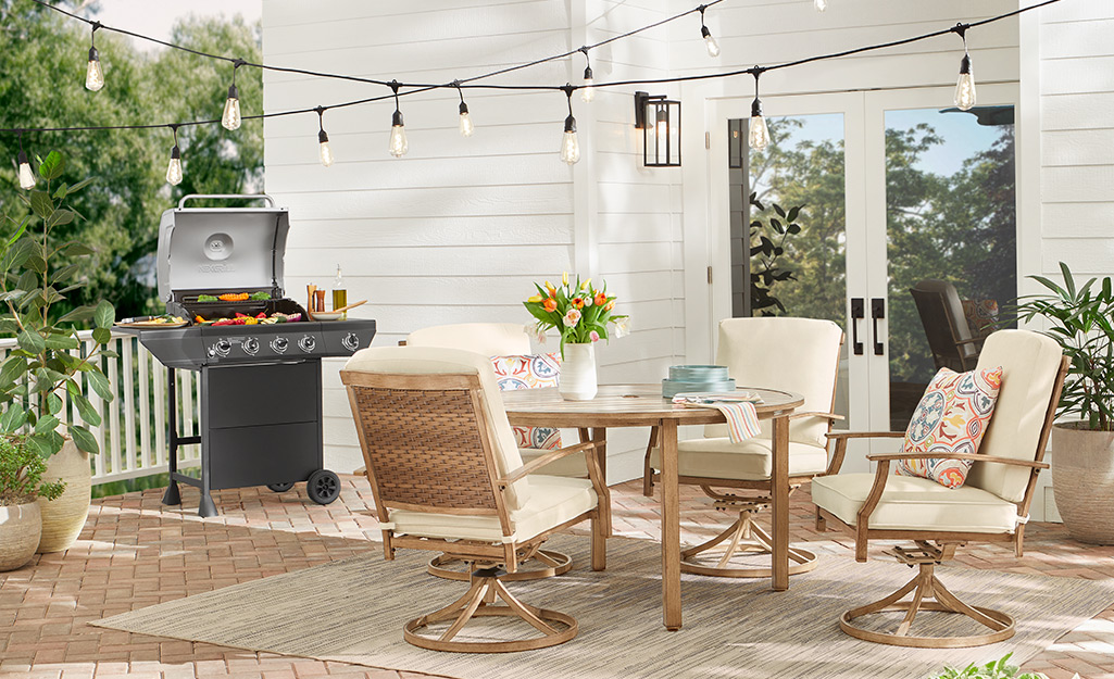 A patio with string lights, a grill and outdoor furniture