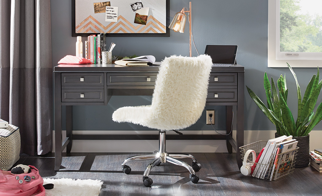 A furry seat cover surrounding a desk chair in a home workspace. A furry seat cover surrounding a desk chair in a home workspace.