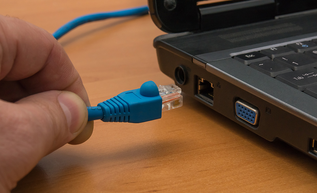 A person about to plug in a finished UTP cable.