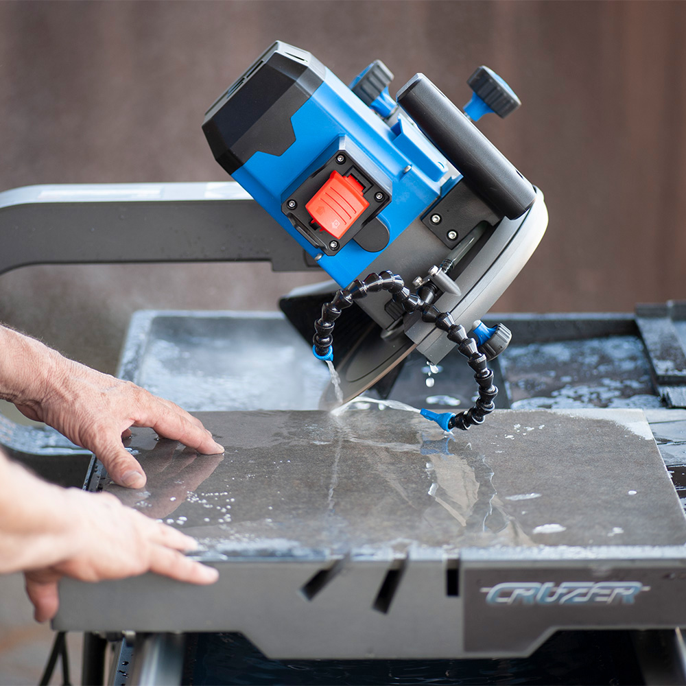 A person cuts tile with a wet saw.