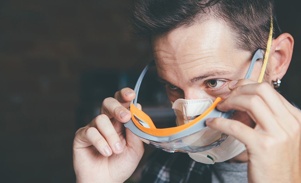 A man putting on safety glasses.