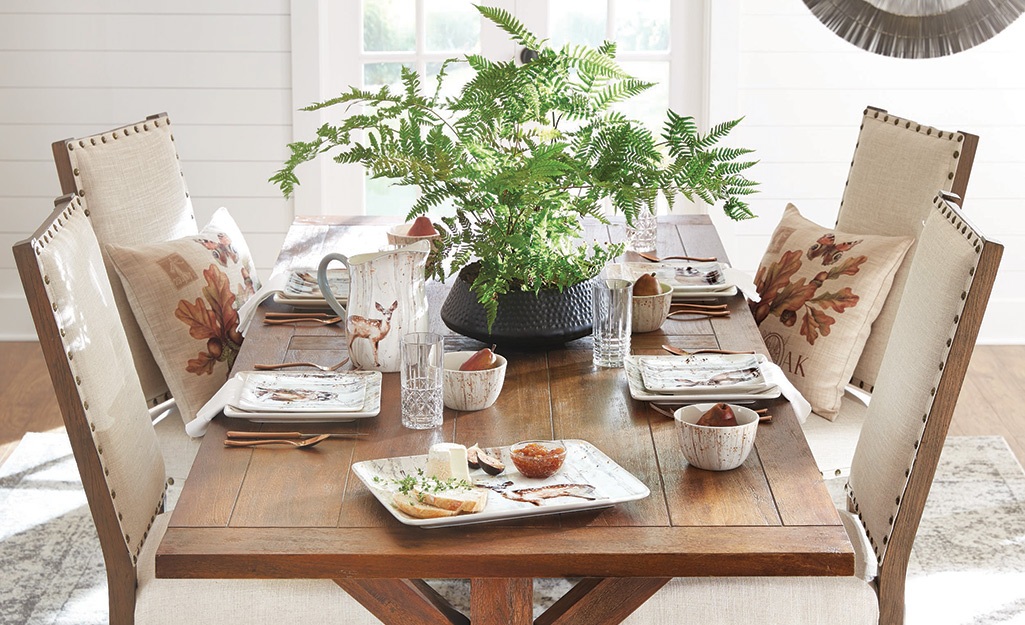 A holiday table with a centerpiece of greenery. A holiday table with a centerpiece of greenery.