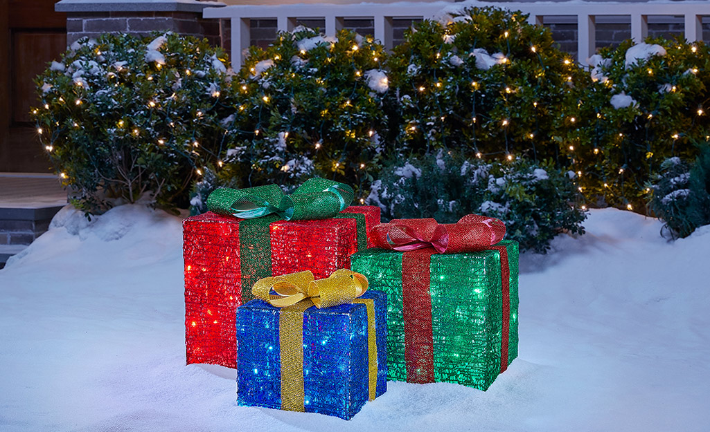 A front yard Christmas display with gifts.