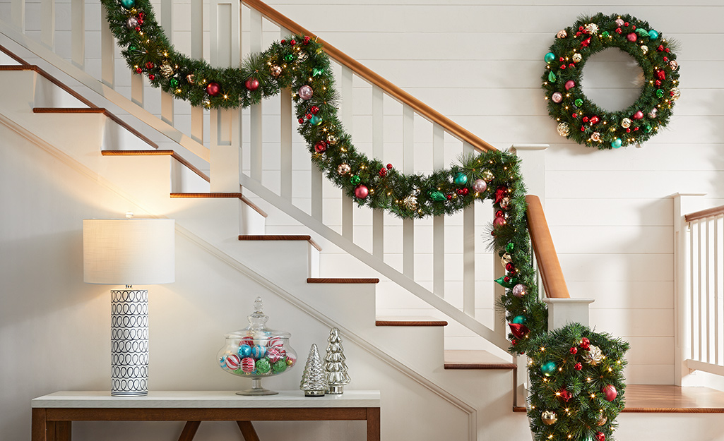 A stair well-wrapped with Christmas garland inside a home.