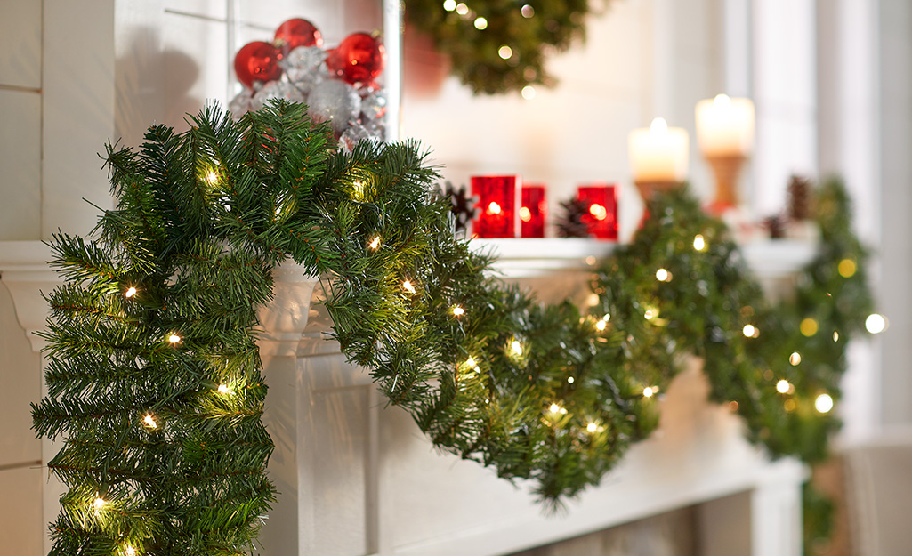 A mantel well-wrapped with Christmas garland inside a home.