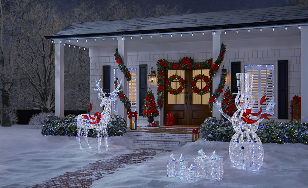 The front of a home well-lit with Christmas lights and lighted decor.
