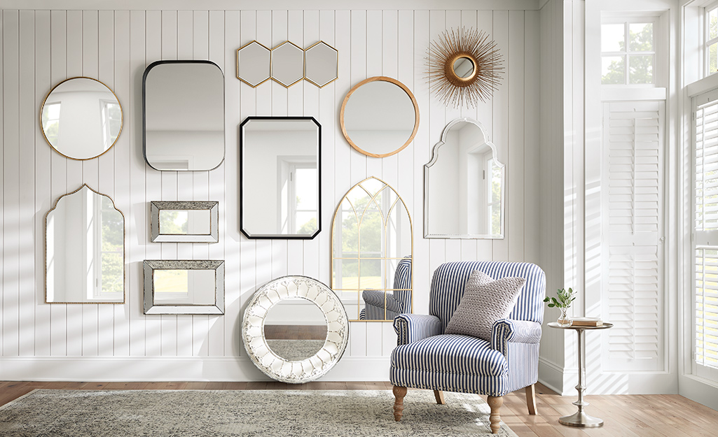 An assortment of decorative mirrors hung to create a gallery wall in a living room.