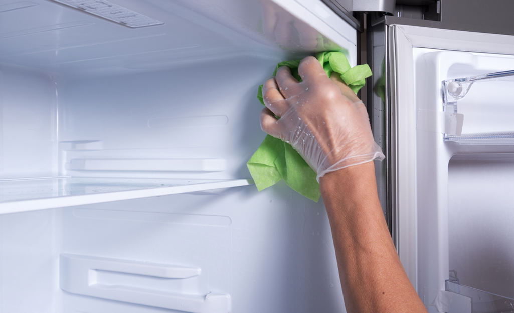 Person cleaning the inside of a fridge. Person cleaning the inside of a fridge.