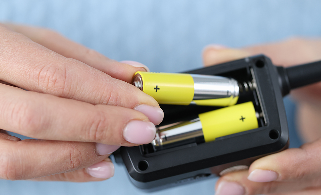 A person inserts a battery into a device.