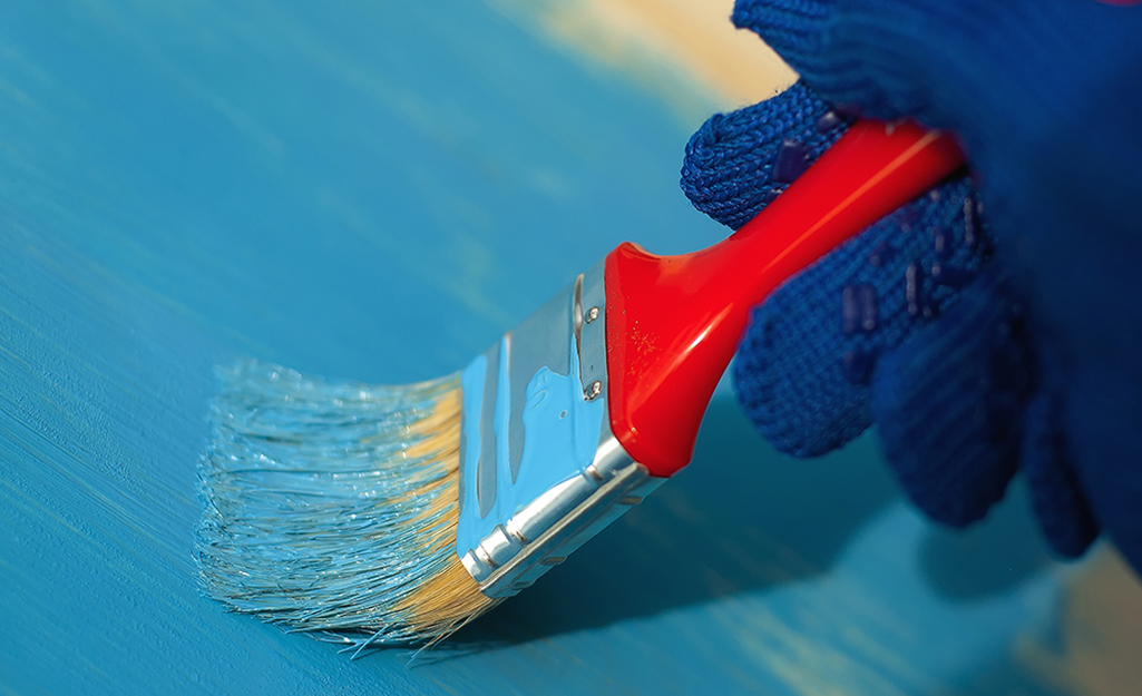 Turquoise paint is painted on a wood surface.