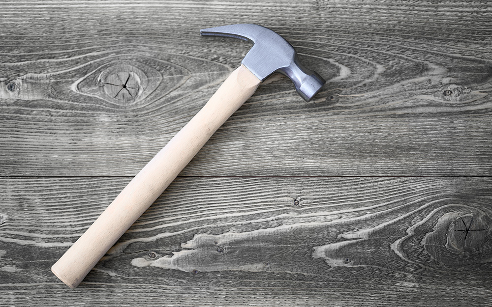 The flat side of a hammer effectively distresses wood.