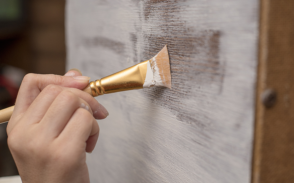 Apply light coat of paint while distressing wood.