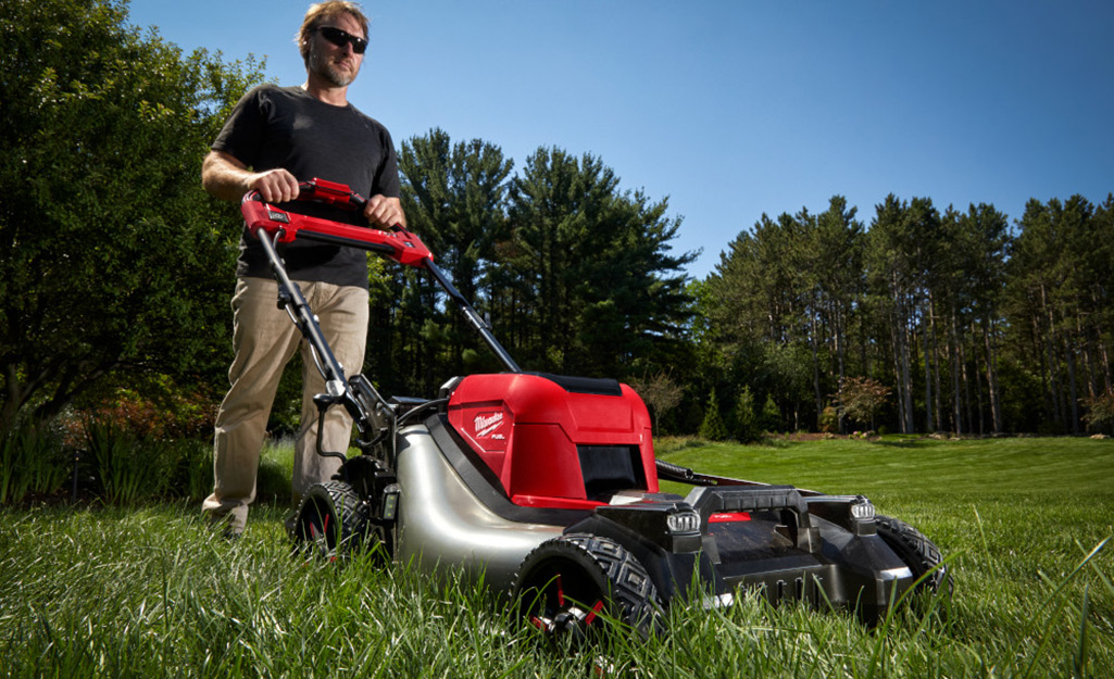 Premium Photo  Lawnmower man with string trimmer and face mask trimmong  grass closeup