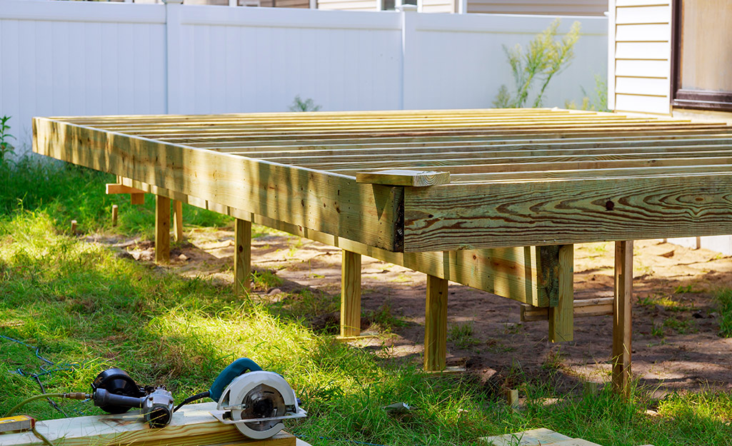 A wooden deck being constructed in a yard.