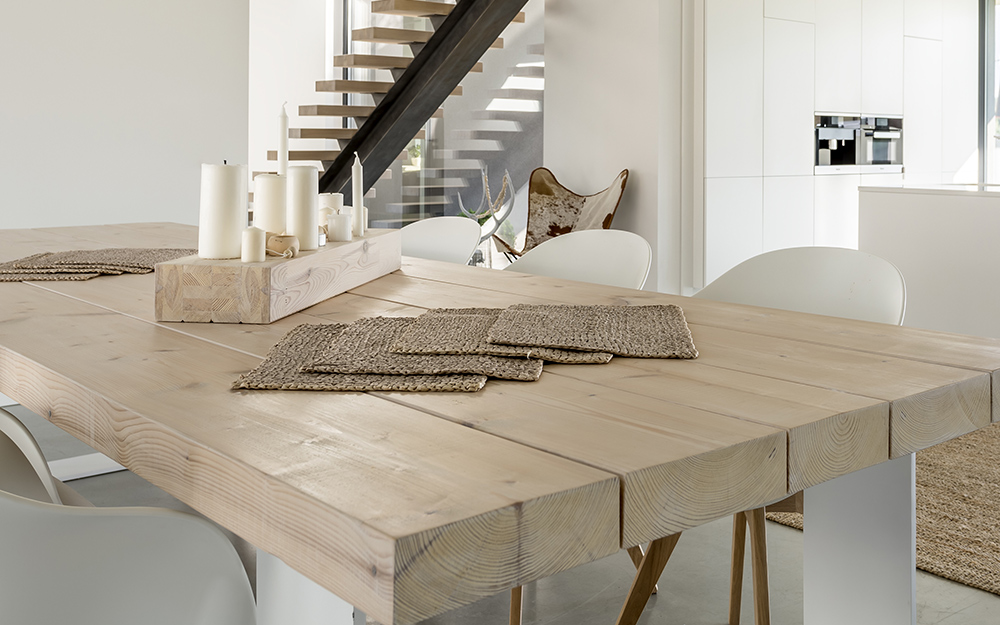 A table with a natural wood finished top and white painted legs. A table with a natural wood finished top and white painted legs.
