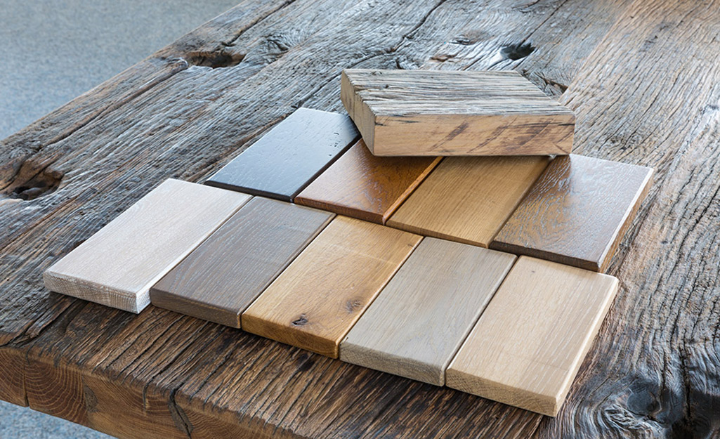 Samples of wood with different finishes lay on a work bench.