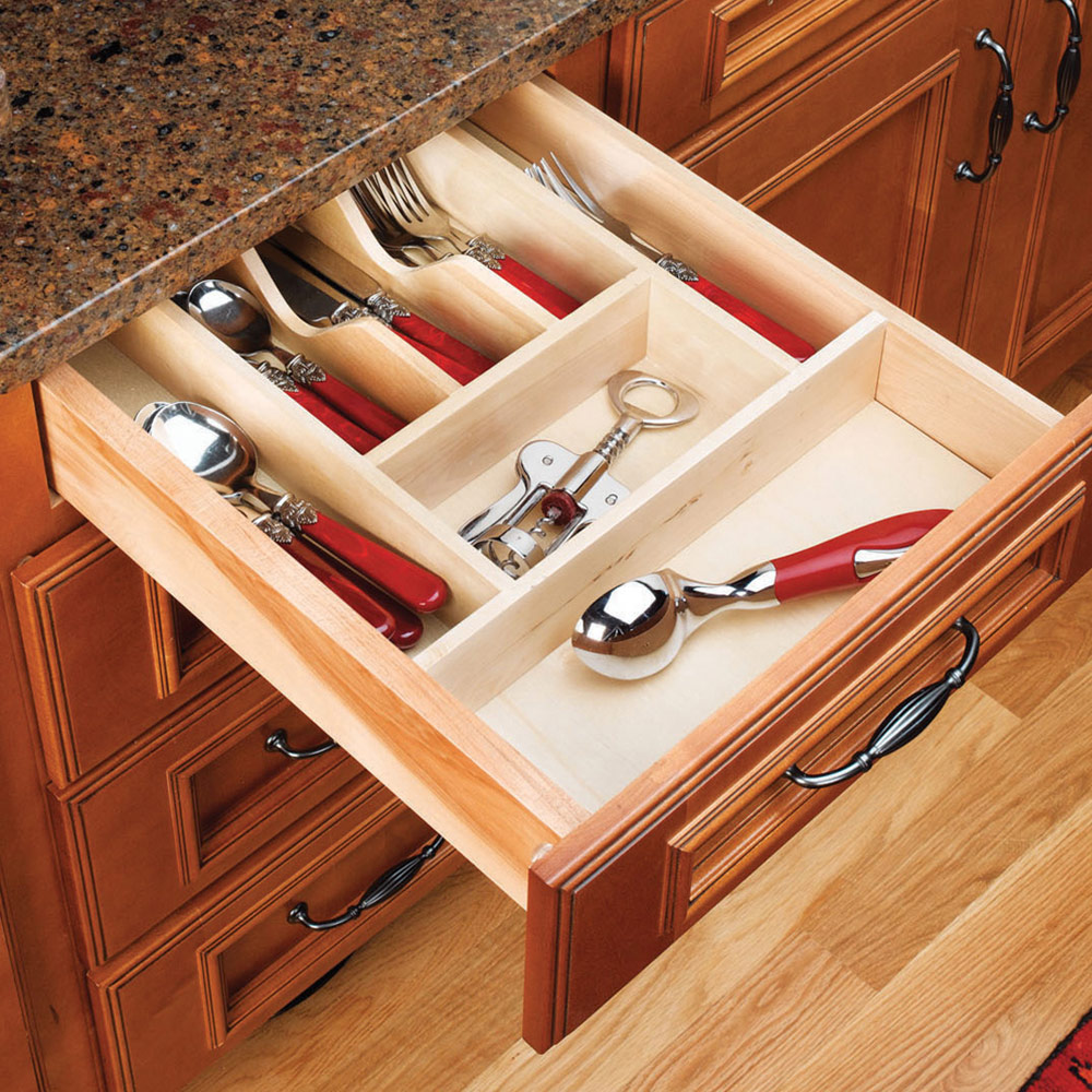 An open kitchen drawer with utensils displayed in slots. 