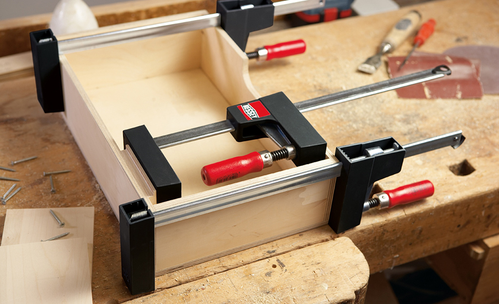 A drawer clamped together with clamps to hold pieces together as glue dries. 