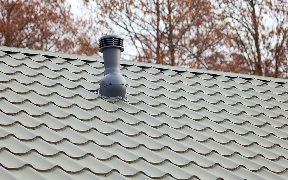 A plumbing vent penetrates the roof of a house and could cause leaks if not properly secured. 