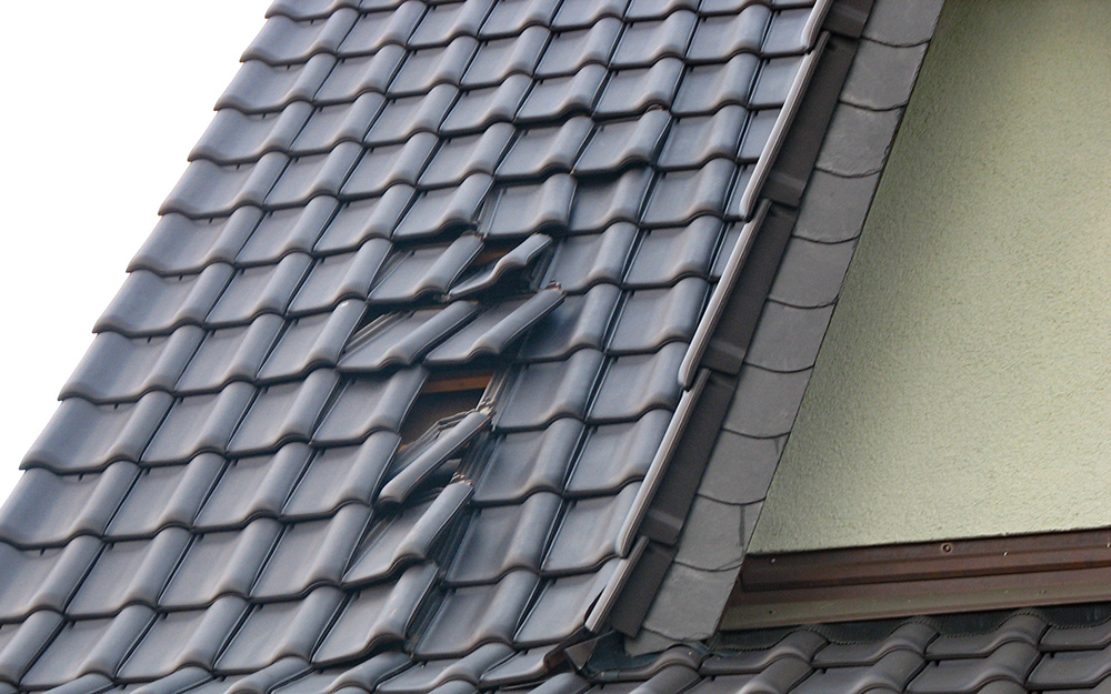 Roofing material on a house appears damaged or improperly installed.