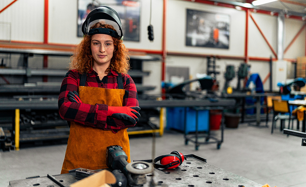 A woman ready to weld in a workshop.