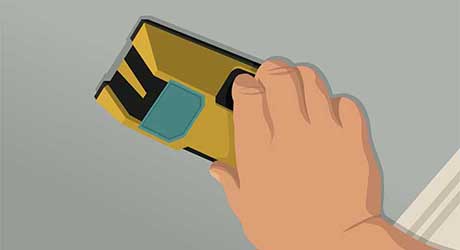 Hand placing stud finder along a ceiling to prepare to frame a new wall Hand placing stud finder along a ceiling to prepare to frame a new wall