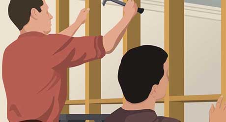 Two people shimming and plumbing a wall frame in place Two people shimming and plumbing a wall frame in place