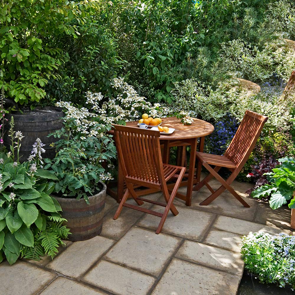 A patio table and chair in a small garden