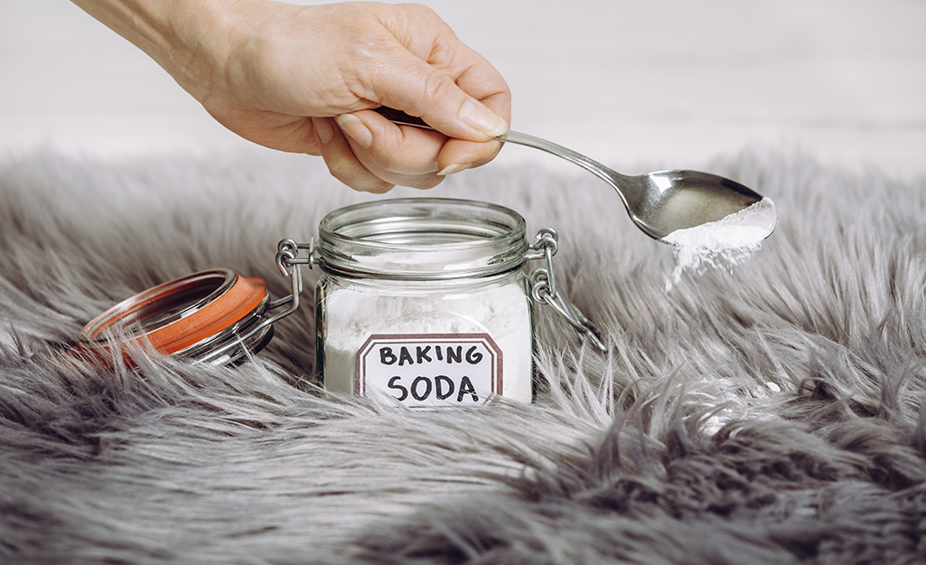 Person using baking soda on carpet.