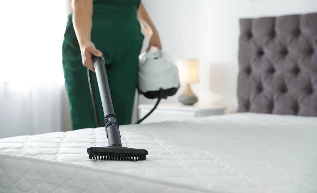 Person vacuuming their mattress.