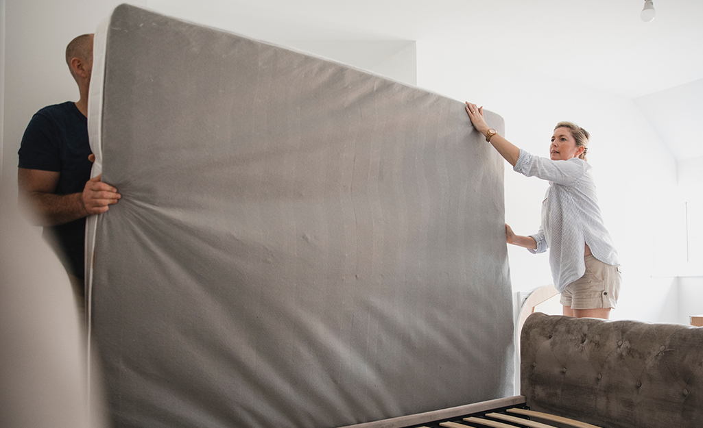 A couple moving their mattress.