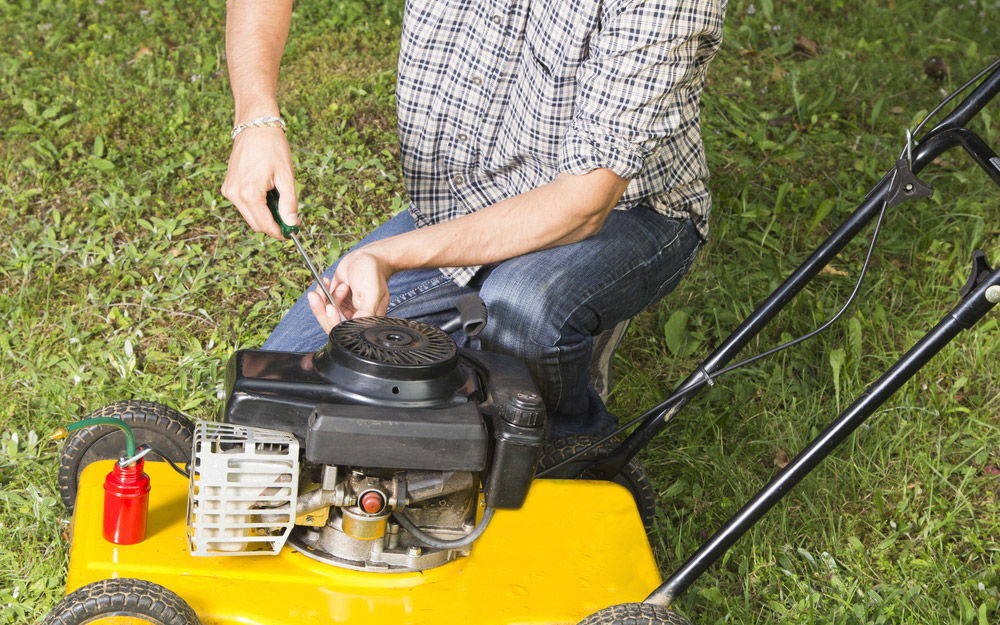 A person working on a lawn mower.