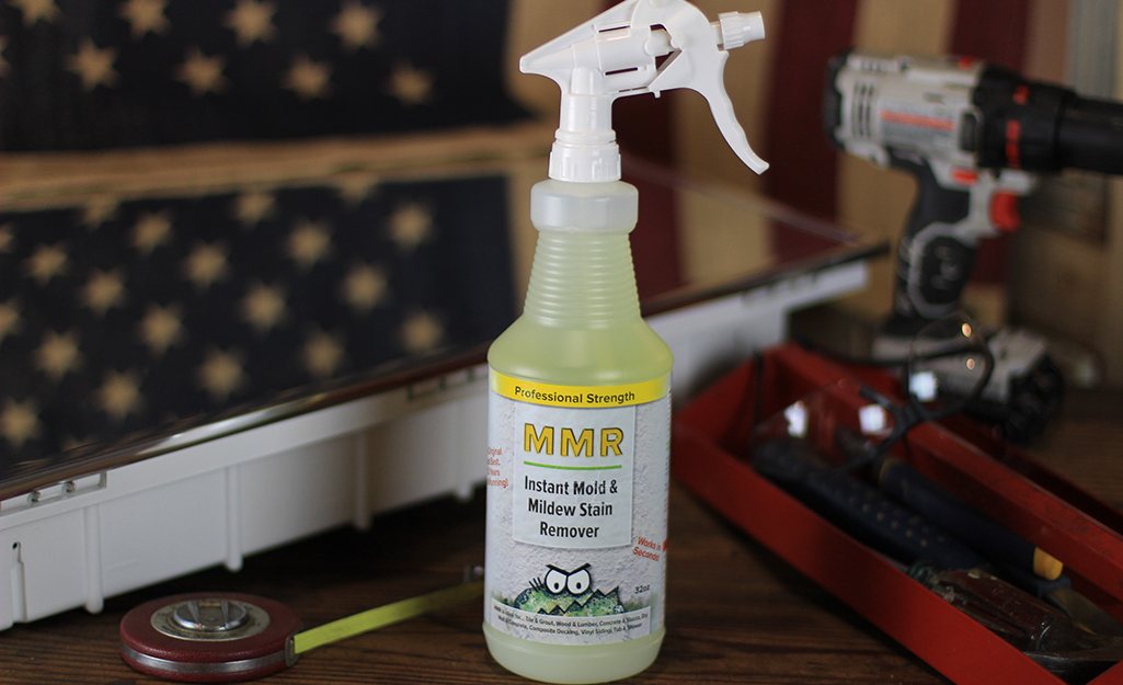 A bottle of mold and mildew stain remover on a worktable.