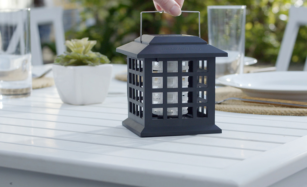 A bug zapper sits on a patio table.