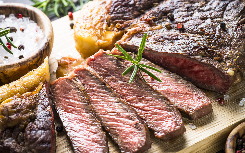 Freshly sliced grilled steak on a cutting board.