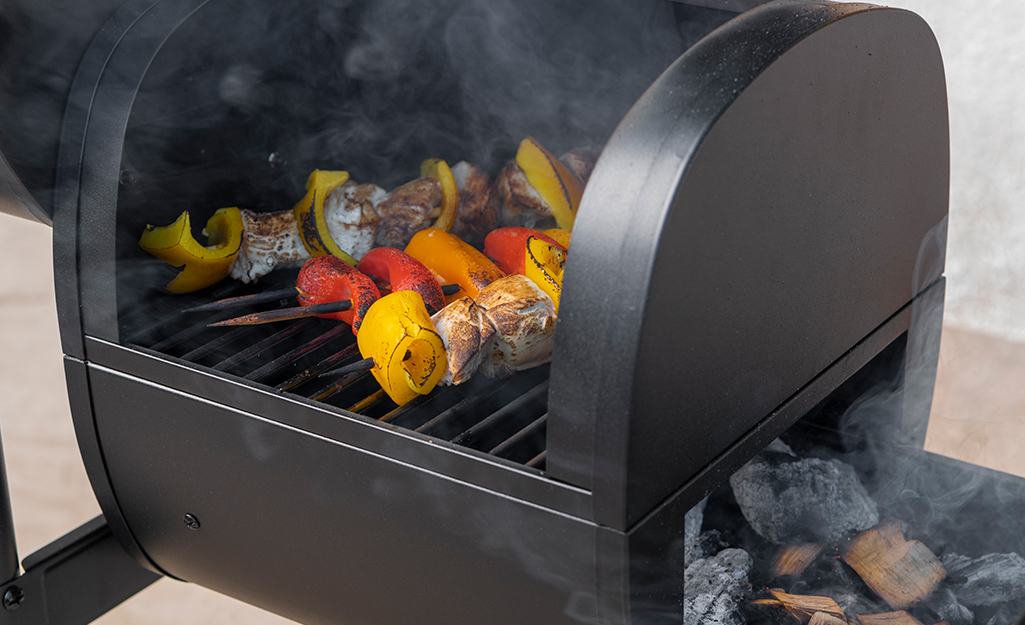 Vegetable skewers cook in a smoker. Vegetable skewers cook in a smoker.