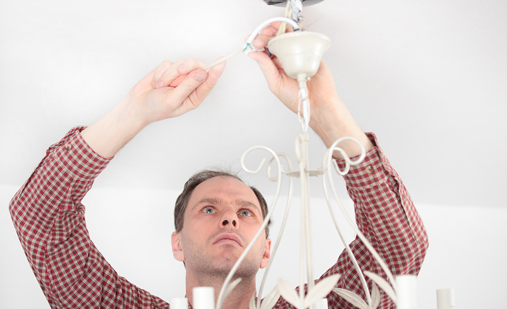 Man wiring a chandelier. 