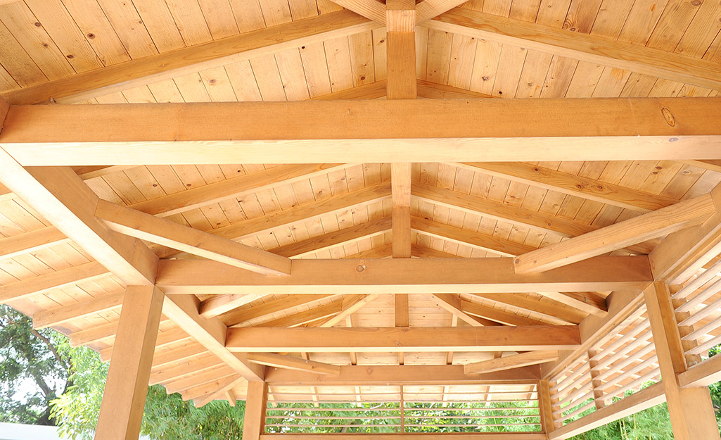 The underside of wood pavilion shows its ceiling joists.