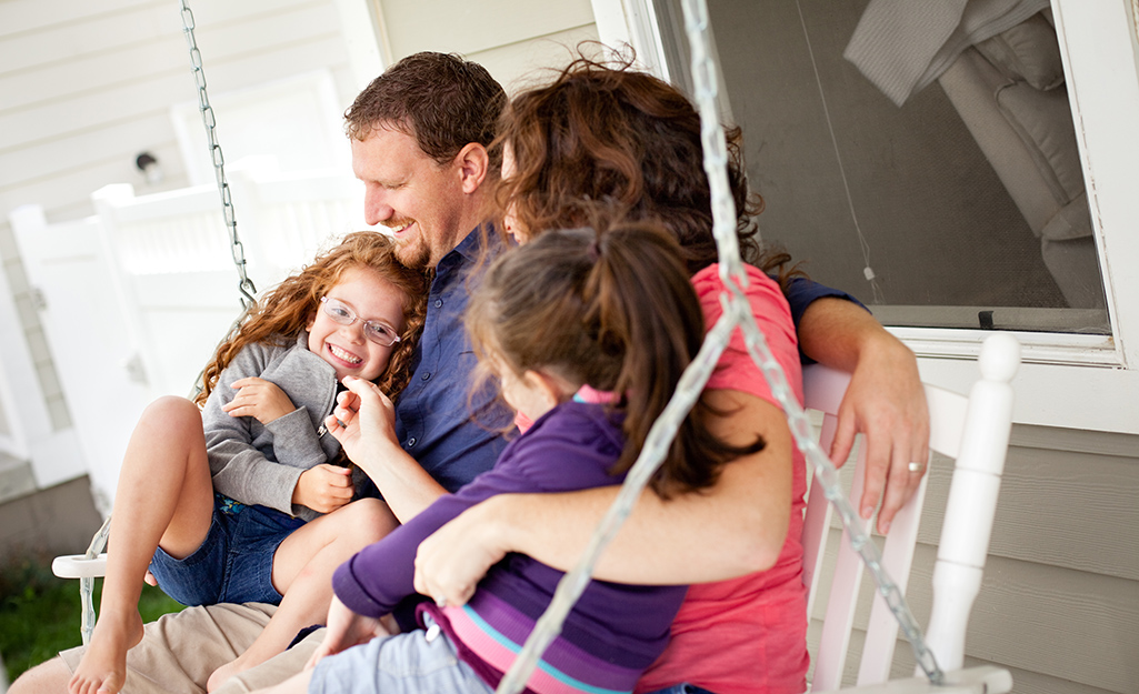 A family sitting on a porch swing.