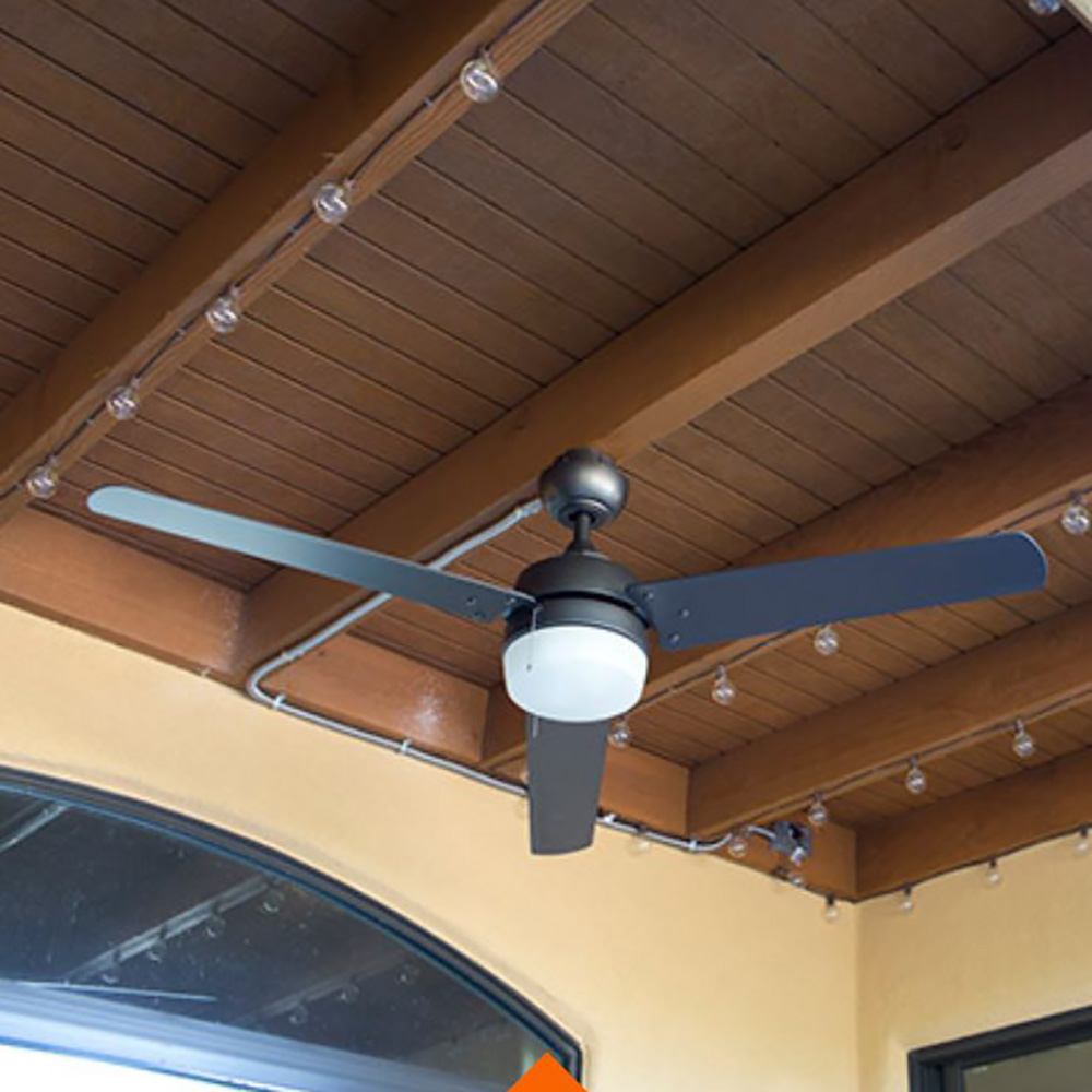 A brown outdoor ceiling with a fan and string lights.