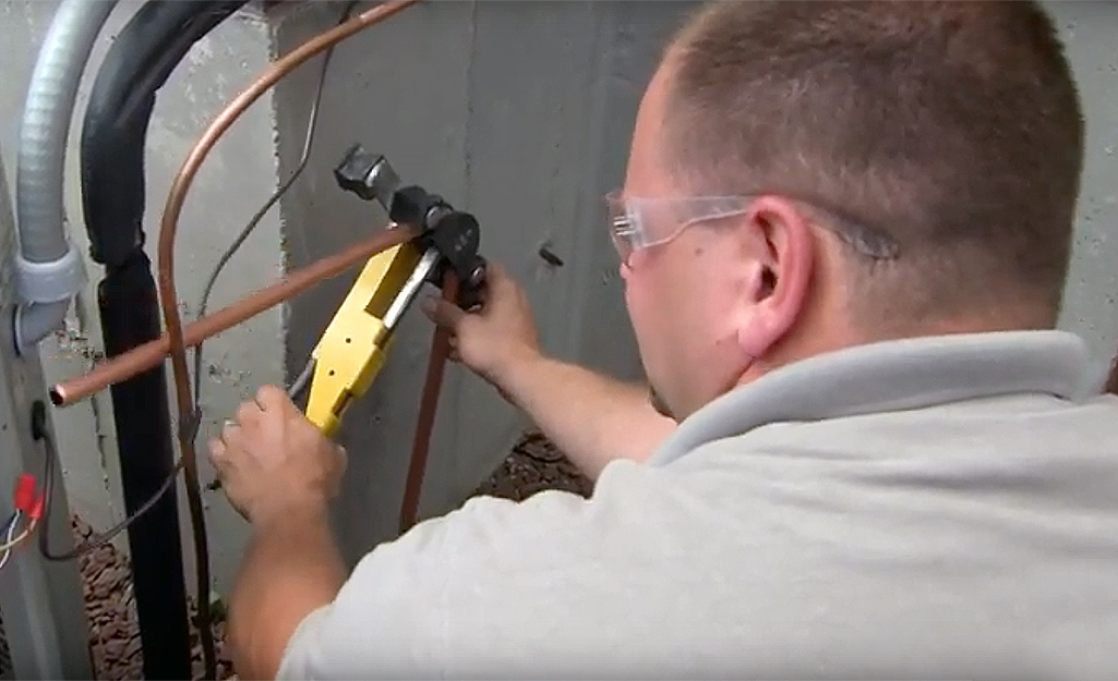 A man cutting a pipe A man cutting a pipe
