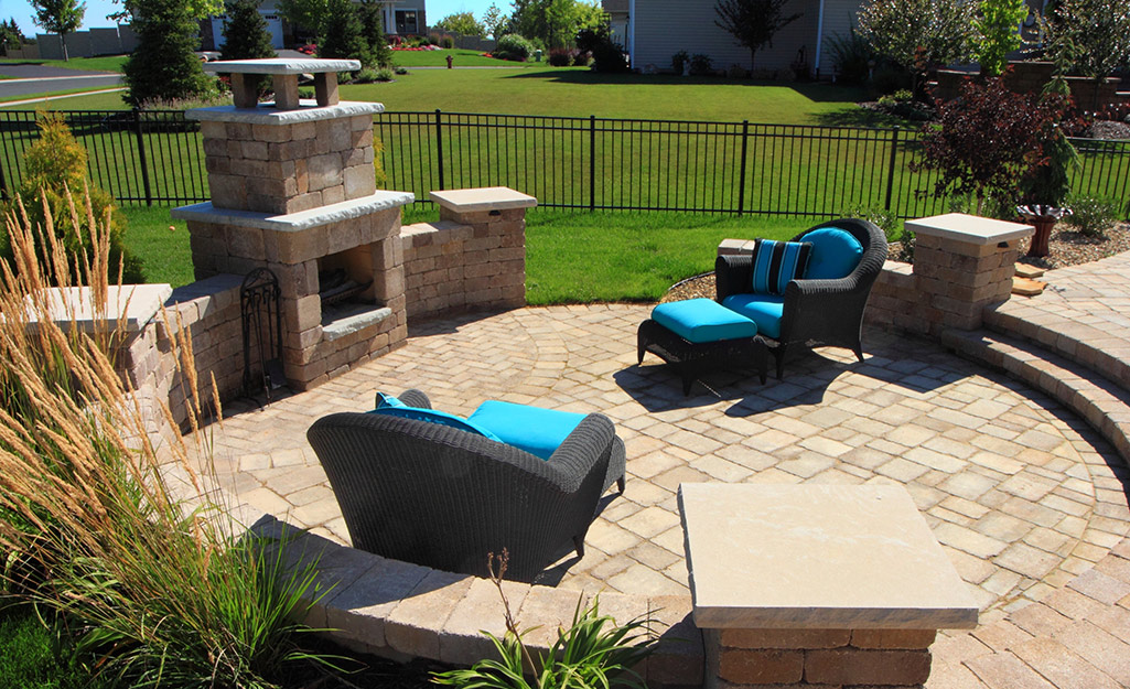 A patio with a large stone outdoor fireplace.